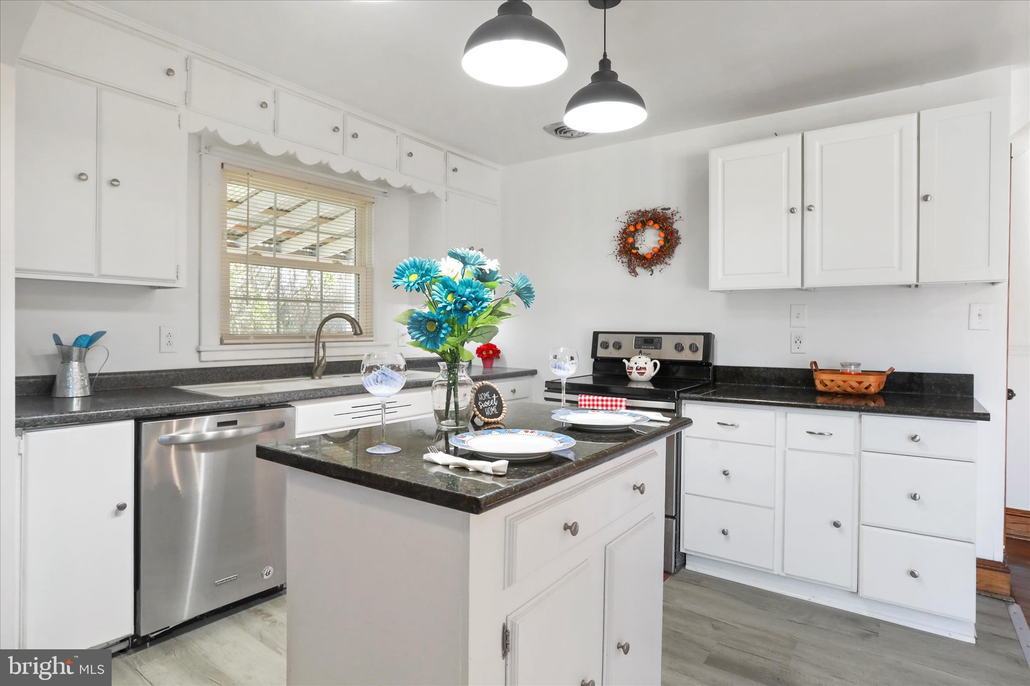 1064 Strasburg Road Front Royal, VA 22630 - Photo 12 of 48 a kitchen with white cabinets and chandelier