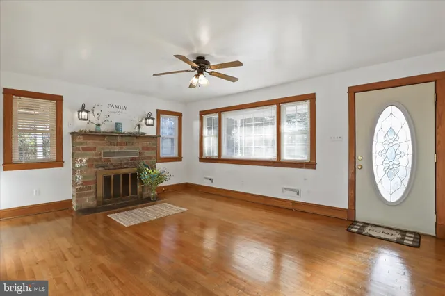 a view of an empty room with window wooden floor and a fireplace