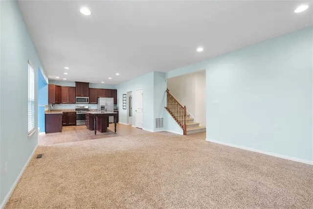 a view of kitchen with refrigerator and wooden floor