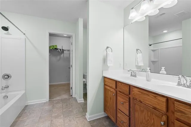 a spacious bathroom with a double vanity sink a mirror and a bathtub