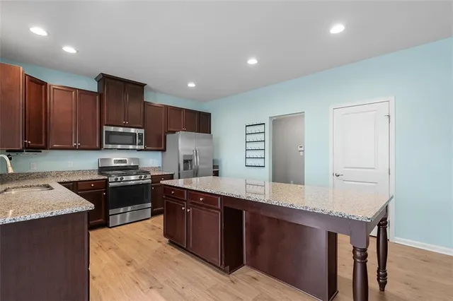 a large kitchen with stainless steel appliances and wooden cabinets