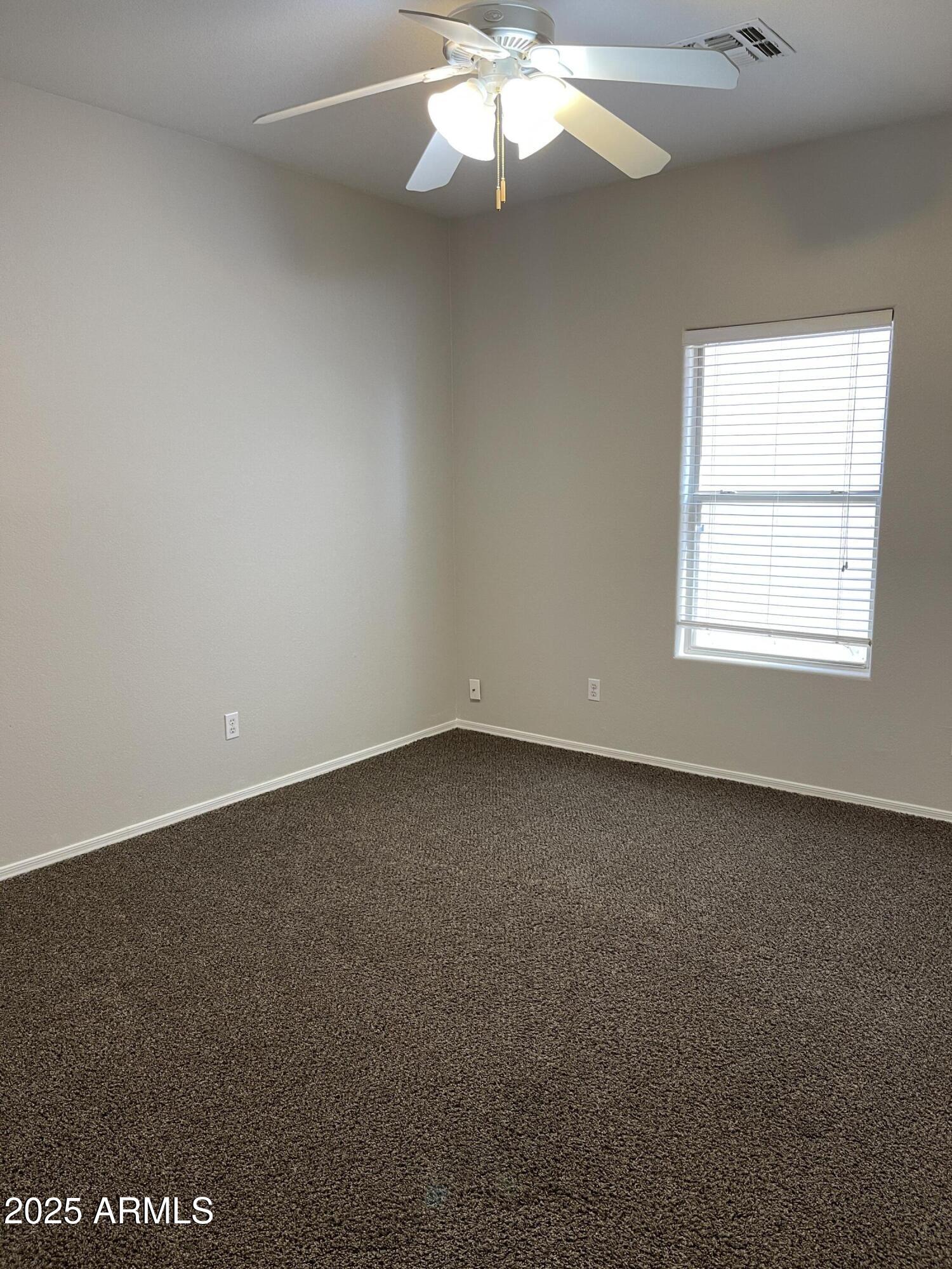 1426 East Ave Isabela Casa Grande, AZ 85122 - Photo 14 of 24 an empty room with a chandelier fan and windows