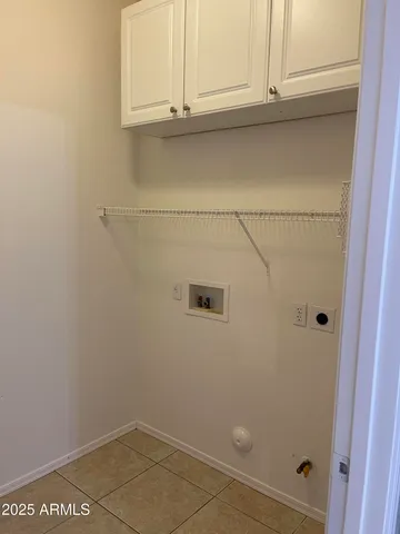 an empty room with a chandelier fan and windows