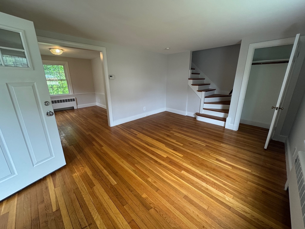 161 Hunnewell Street, Unit 1 Needham, MA 02494 - Photo 2 of 13 a view of kitchen and empty room with wooden floor