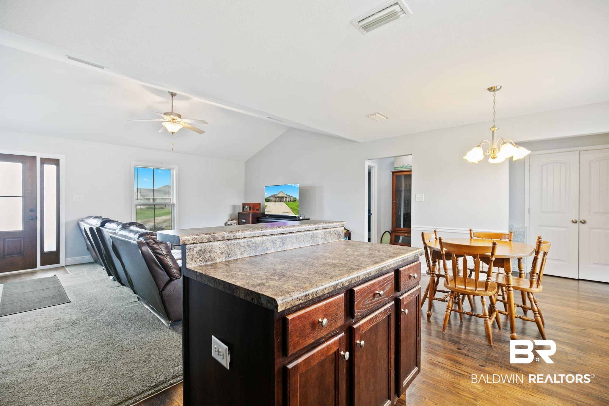 15573 Talus Court Foley, AL 36535 - Photo 18 of 50 Kitchen with lofted ceiling, light hardwood / wood-style flooring, ceiling fan with notable chandelier, a kitchen island, and pendant lighting