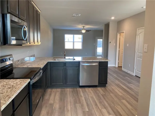 a kitchen with a sink stove top oven and cabinets