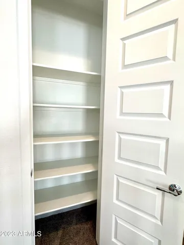 a view of walk in closet with empty racks