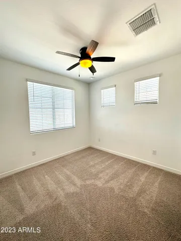 an empty room with a window and a ceiling fan
