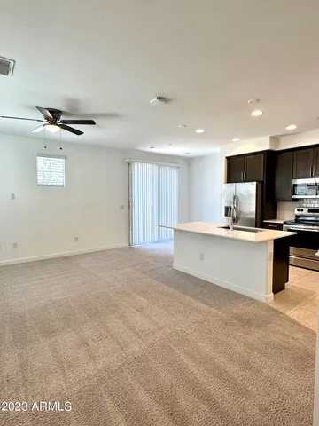 a kitchen with stainless steel appliances kitchen island granite countertop a stove top oven a sink a counter top space and cabinets