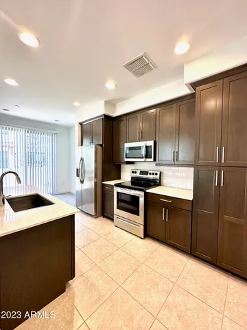 a kitchen with granite countertop a refrigerator and a stove top oven