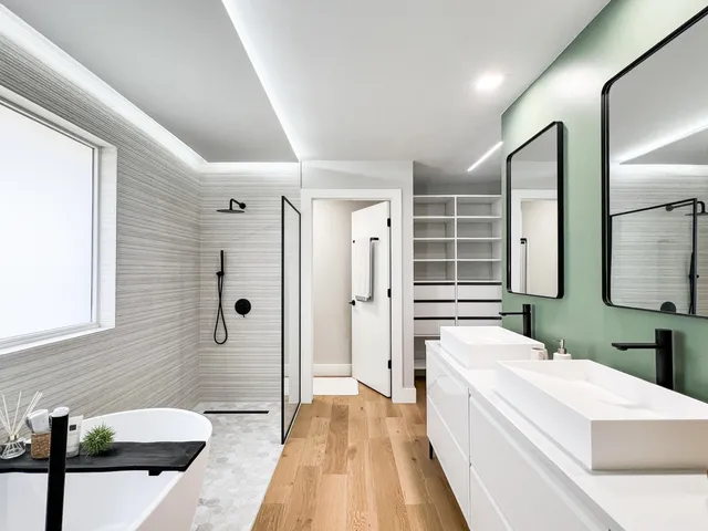 a spacious bathroom with a double vanity sink a large mirror and shower