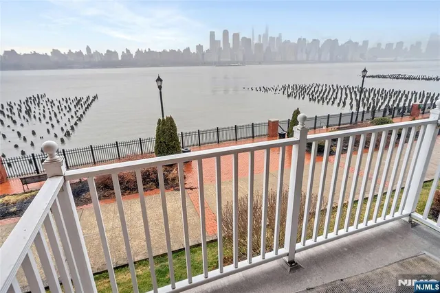 a view of a balcony with wooden floor and lake view