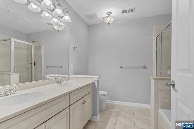 a bathroom with a double vanity sink a toilet and a mirror