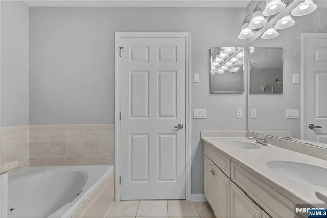 a bathroom with a tub sink and a mirror
