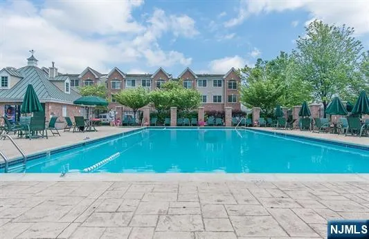 a view of multiple houses with yard and swimming pool