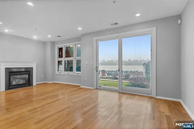 a view of an empty room with a fireplace and a window