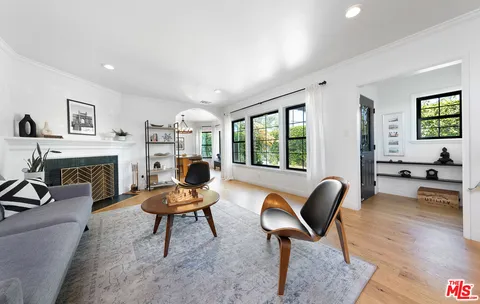 a living room with furniture a fireplace and a large window
