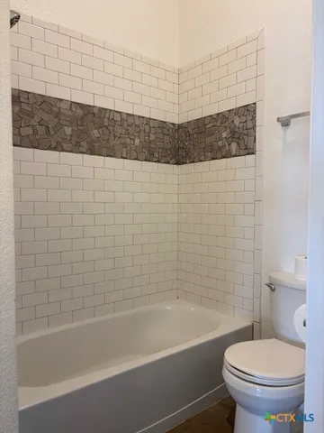 a bathroom with a bathtub and toilet