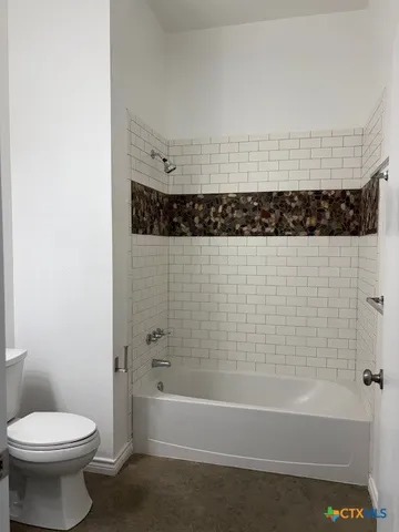 a bathroom with a bathtub and a toilet