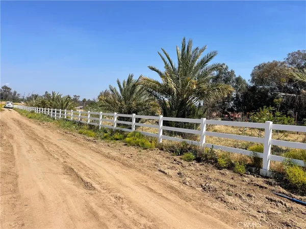 a view of a yard with wooden fence
