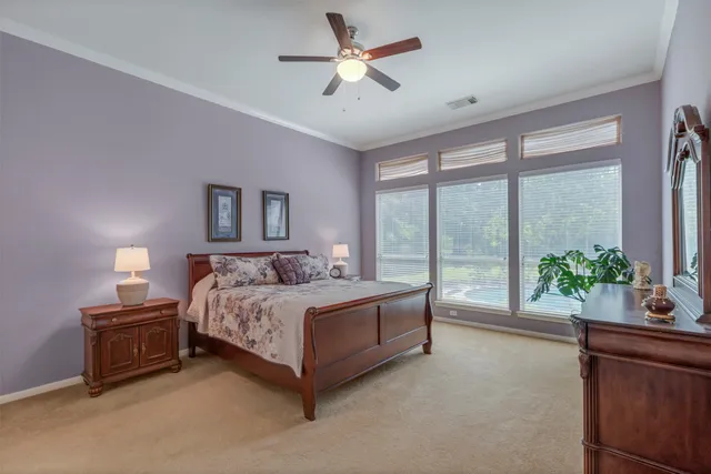a spacious bedroom with a balcony a bed and a chandelier