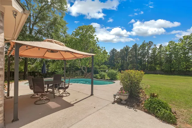 a view of a patio with a table and chairs under an umbrella