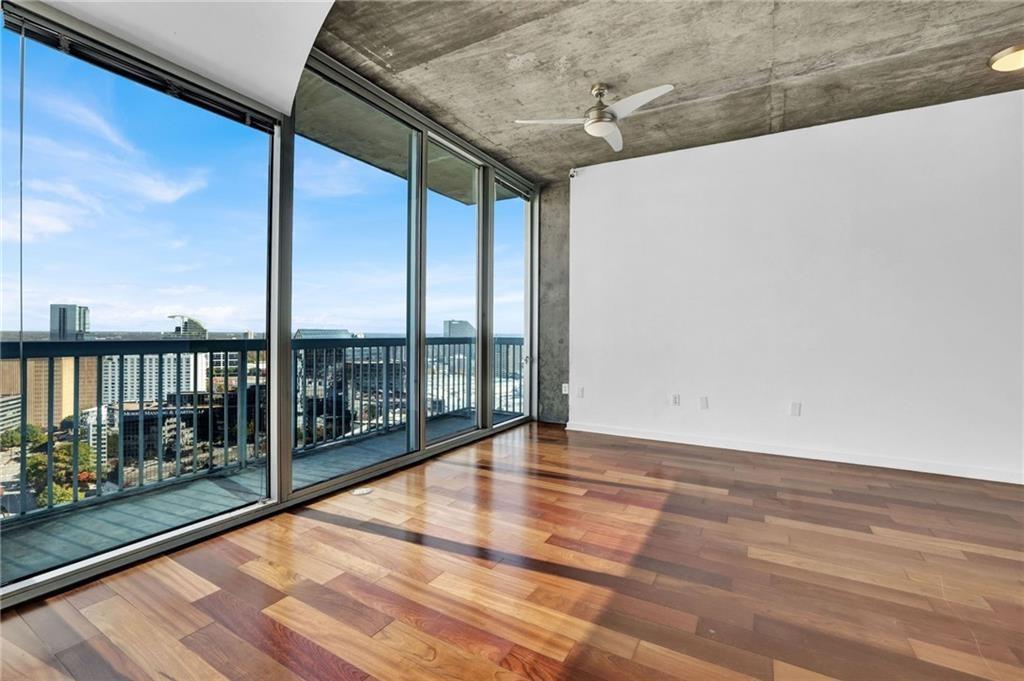 3324 Peachtree Road Northeast, Unit 2507 Atlanta, GA 30326 - Photo 4 of 25 a view of an empty room with wooden floor and floor to ceiling window