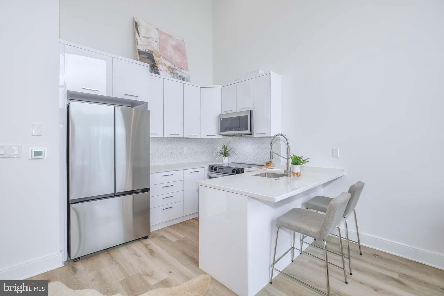 4328 Georgia Avenue Northwest, Unit 401 Washington, DC 20011 - Photo 11 of 32 a kitchen with a refrigerator a stove a sink and a cabinets