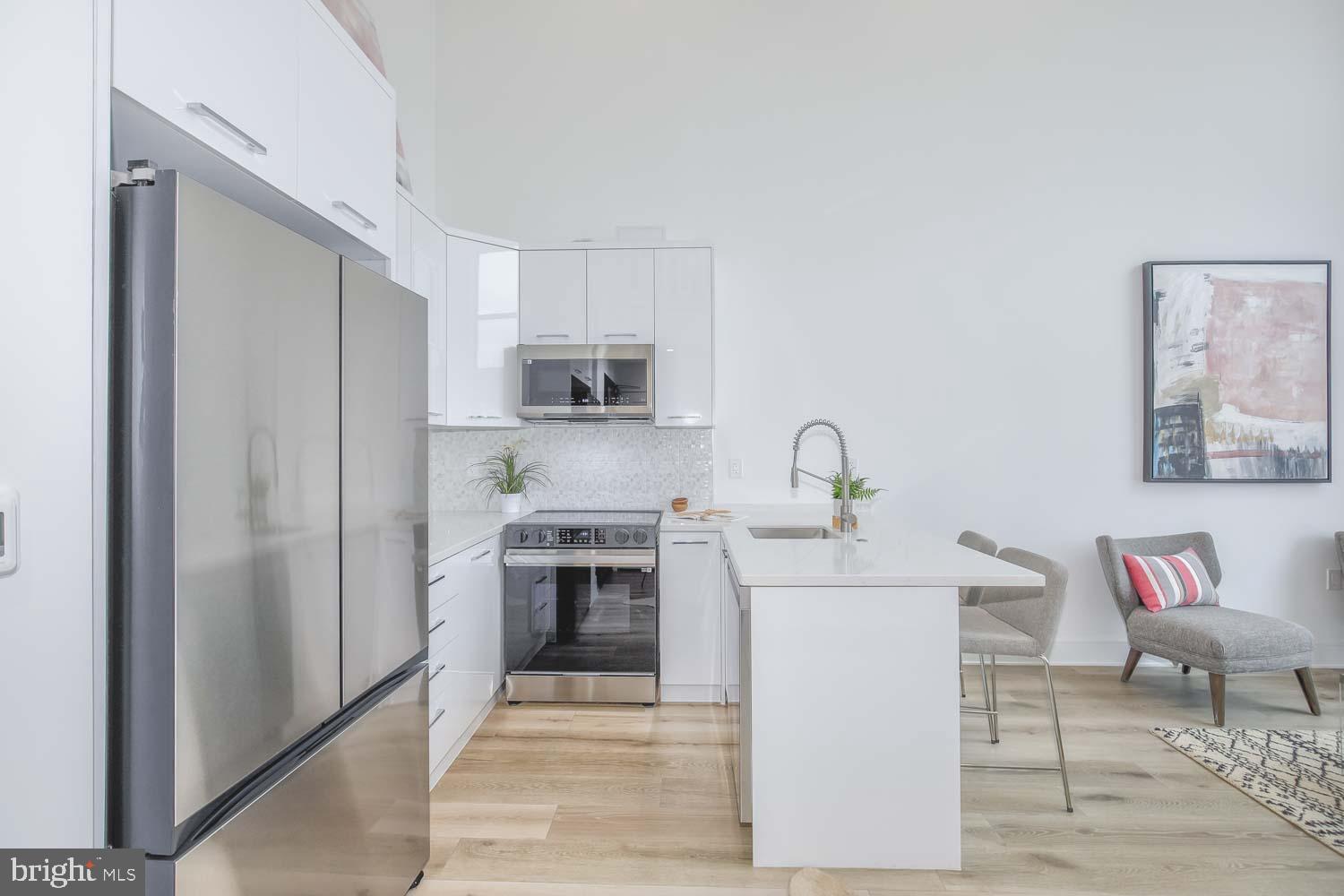 4328 Georgia Avenue Northwest, Unit 401 Washington, DC 20011 - Photo 14 of 32 a kitchen with stainless steel appliances granite countertop a refrigerator sink and stove