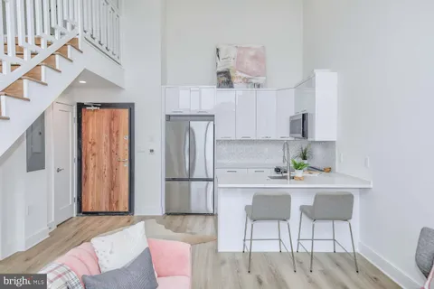 a kitchen with stainless steel appliances kitchen island granite countertop a refrigerator and a stove top oven