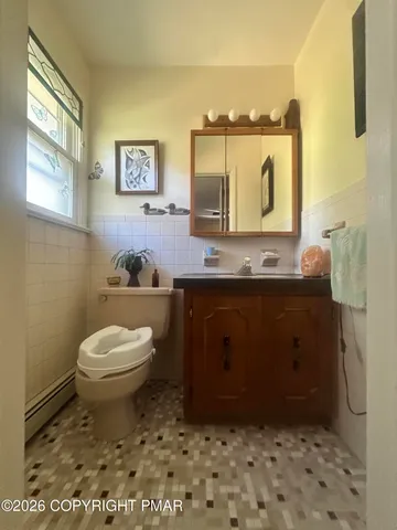 a bathroom with a toilet a sink and mirror