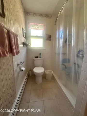 a bathroom with a granite countertop sink a toilet and shower