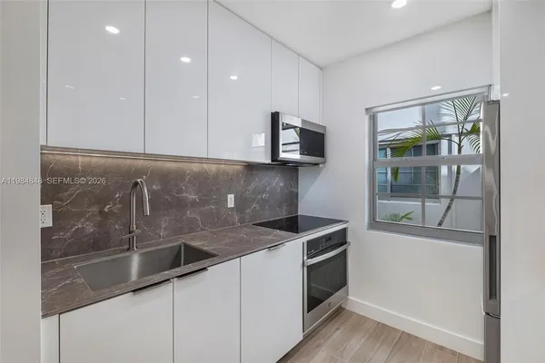 a kitchen that has a sink and a stove top oven