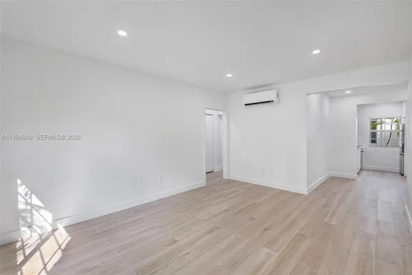 a view of an empty room with wooden floor
