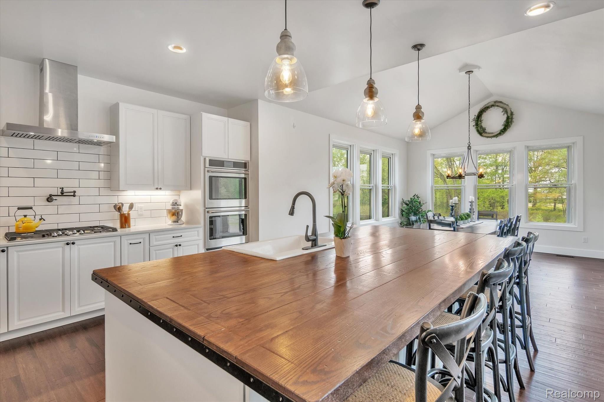 6100 Hartland Road Fenton, MI 48430 - Photo 12 of 67 Kitchen features custom island w/ farmhouse sink, walk-in pantry, full size fridge, full size freezer, double oven, quartz countertops, all stainless steel appliances and soft close cabinets.