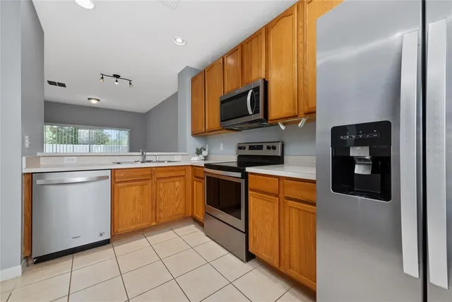 a kitchen with stainless steel appliances granite countertop a refrigerator and a stove top oven