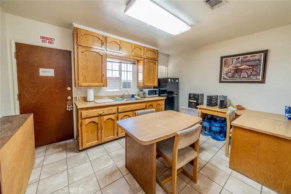 a kitchen with a stove a sink a counter top space and cabinets