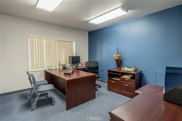 a living room with furniture a desk and a window
