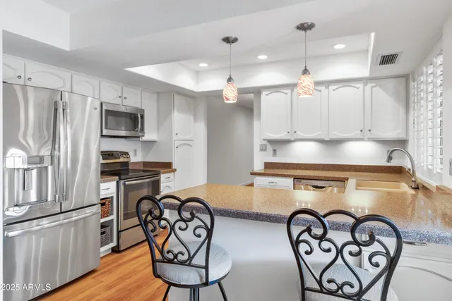 a kitchen with granite countertop a sink and white cabinets