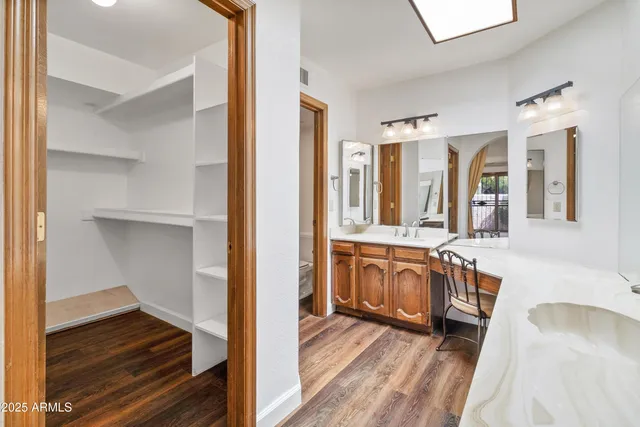 a bathroom with a granite countertop sink toilet a large mirror a shower and a bathtub