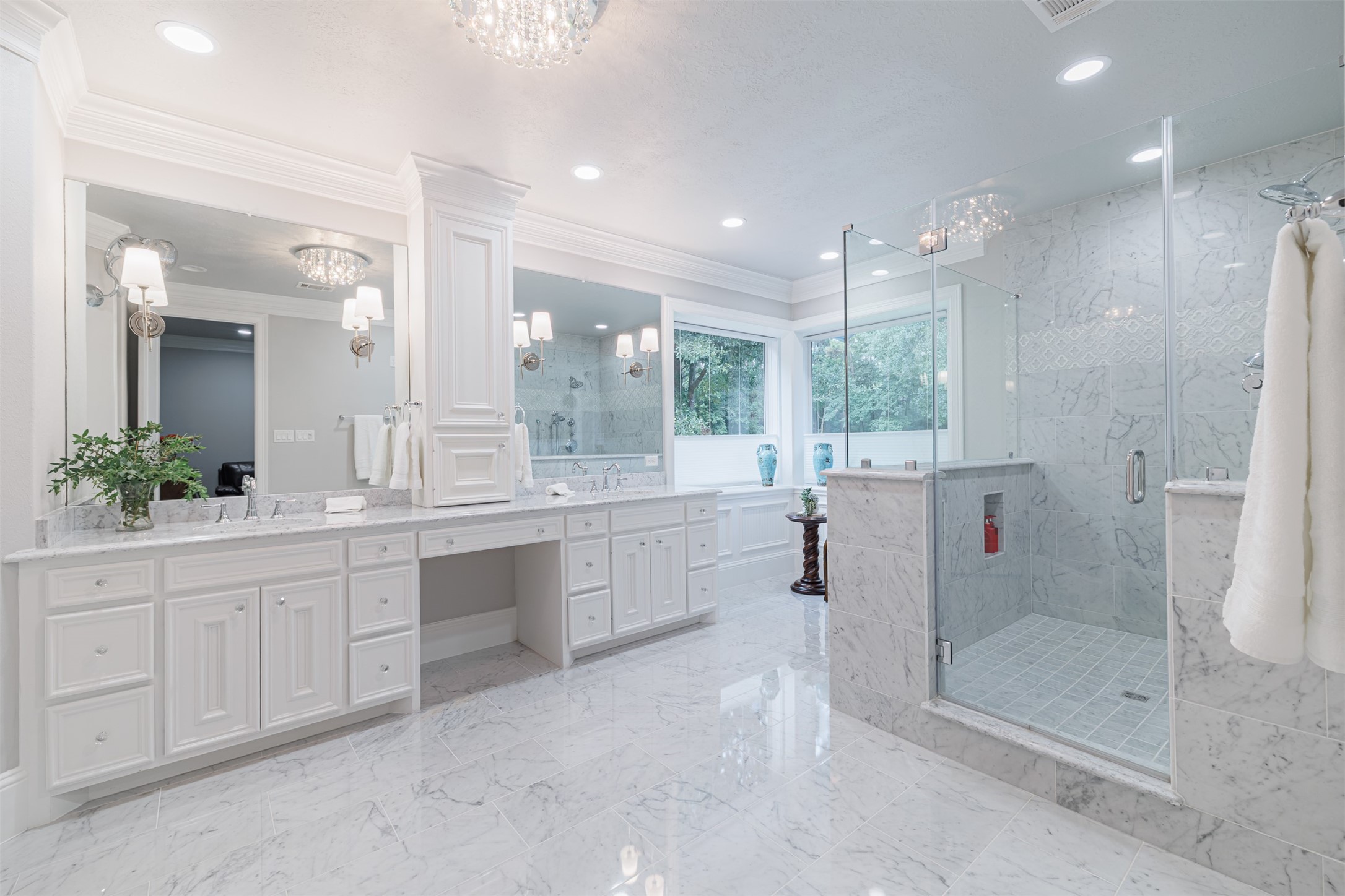 16636 Stonecrest Drive Conroe, TX 77302 - Photo 2 of 40 Wrapped in marble and aglow with crystal fixtures, the primary bathroom is a dreamscape. Soft light dances off every surface, while a wall of windows connects you to the calming beauty of nature.