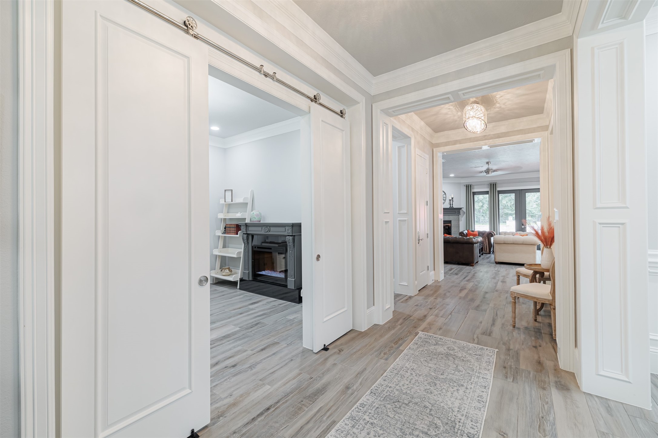 16636 Stonecrest Drive Conroe, TX 77302 - Photo 26 of 40 Moving deeper inside, elegant barn doors reveal a sophisticated study, while tasteful finishes, intricate molding, and sparkling fixtures continue to guide your senses seamlessly toward the inviting warmth of the living area.