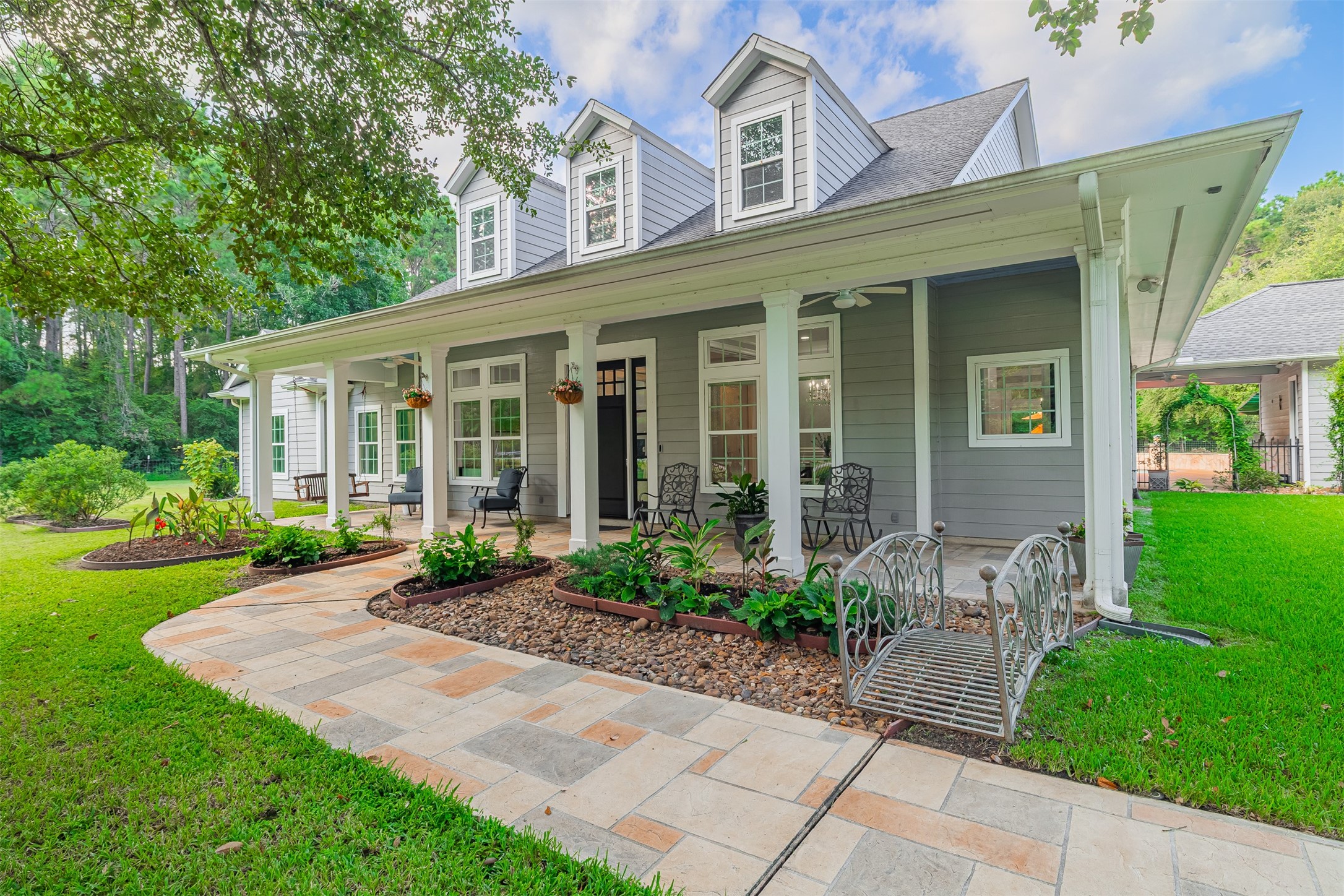 16636 Stonecrest Drive Conroe, TX 77302 - Photo 39 of 40 The front porch beckons you to pause. Rocking chairs sway gently, a soft breeze rustles through the hanging ferns, and you’re reminded how rare it is to feel this kind of calm.