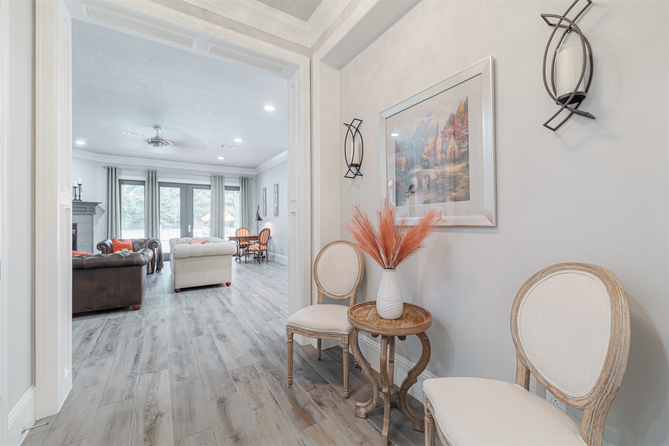 16636 Stonecrest Drive Conroe, TX 77302 - Photo 4 of 40 Welcome guests through this elegant hallway that opens into a sun-kissed living space. The triple crown molding and curated wall sconces create a feeling of luxury and calm. It’s an entrance that invites you to exhale.