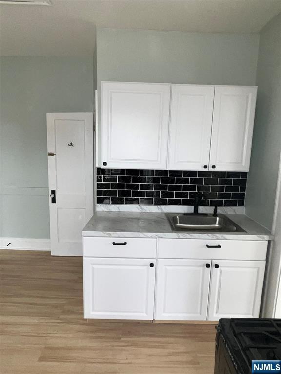 193 President Street, Unit 9 Passaic, NJ 07055 - Photo 9 of 11 a view of cabinets a wooden floor and a sink