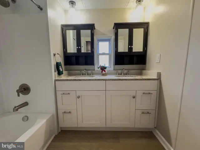 a bathroom with a tub sink and mirror