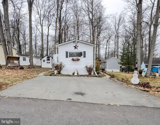 a view of a white house that has a tree on the side of it