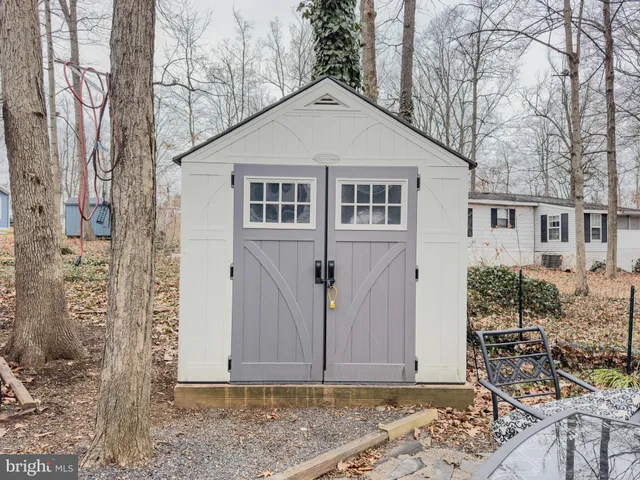 a view of a white house with large windows and wooden fence