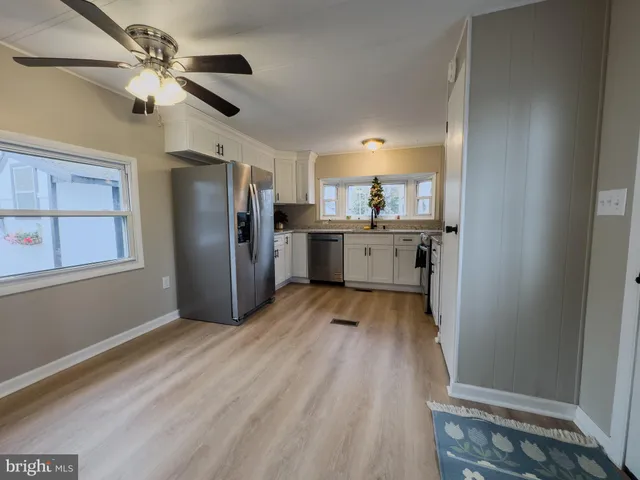 a kitchen with cabinets and wooden floor