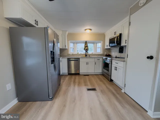a kitchen with stainless steel appliances granite countertop a refrigerator stove and sink